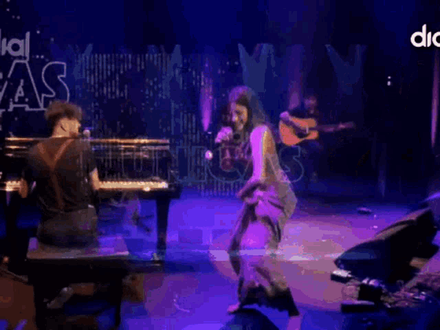 a man playing a piano and a woman singing on a stage with a sign behind them that says " special as "