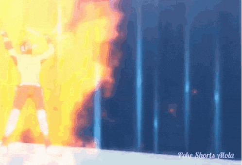 a man is standing in front of a wall with flames coming out of it ..