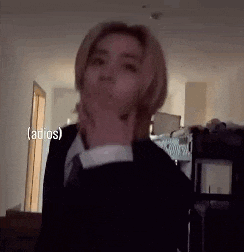 a woman in a suit and tie is making a funny face in a room .