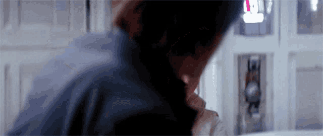 a man is holding a woman 's neck in a room .