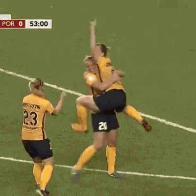 a group of female soccer players are hugging and celebrating a goal