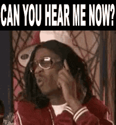 a man wearing glasses and a red jacket is talking on a cell phone and asking can you hear me now .