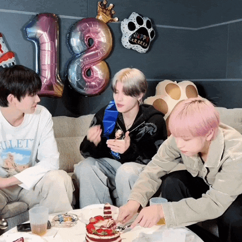 a group of young men are celebrating their 18th birthday with balloons and cake
