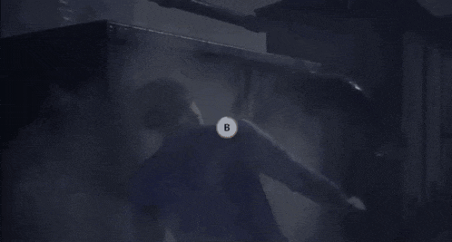 a person is holding a gun in a dark room in a blurry photo .