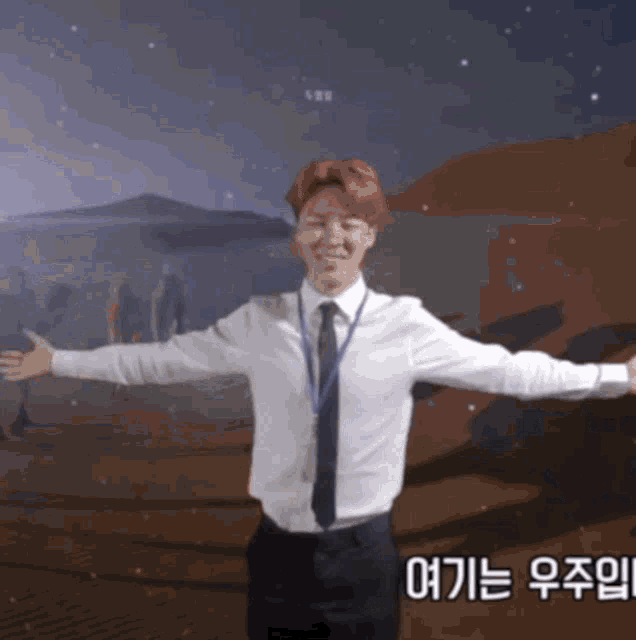 a man in a white shirt and black tie with his arms outstretched