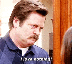a man with a mustache is standing in front of a door and saying `` i love nothing '' .