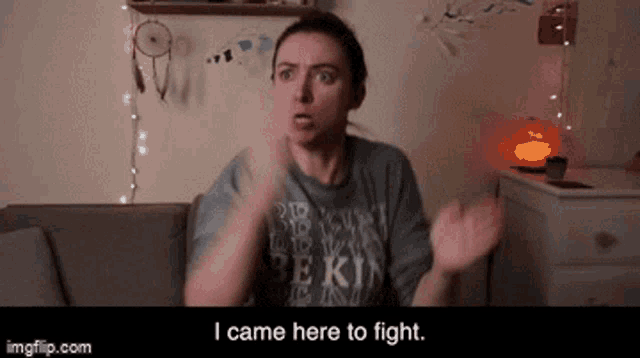 a woman is sitting on a couch and says i came here to fight .