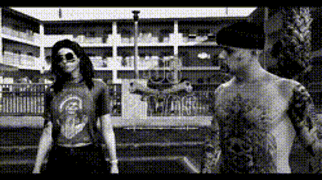 a man without a shirt is standing next to a woman with long hair