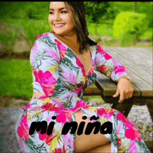 a woman in a floral dress sits on a picnic table with the words " mi niña " on the bottom