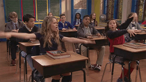 a group of students are sitting at their desks in a classroom .