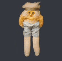 a stuffed animal with a yellow shirt and blue shorts on
