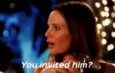 a woman is holding a glass of wine and asking if she invited him