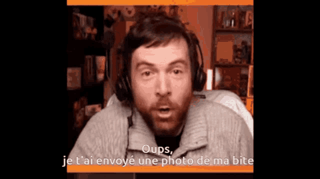 a man with a beard wearing headphones says oops je t'ai envoye une photo de ma bite