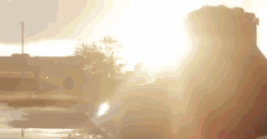 the sun is shining through the clouds and a person is standing in the foreground .