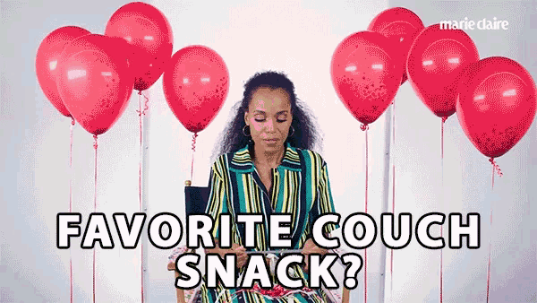 a woman sitting in a chair with red balloons behind her and the words favorite couch snack