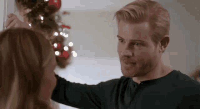 a man is putting a wreath on a woman 's head .