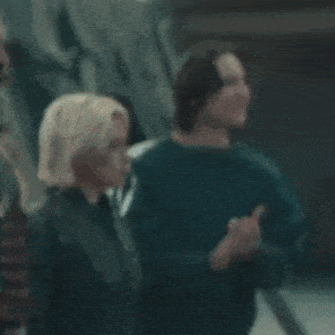 a man and a woman are standing next to each other and clapping .