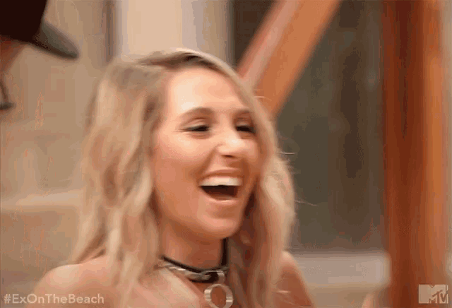 a woman is laughing with her mouth open and wearing a choker around her neck .