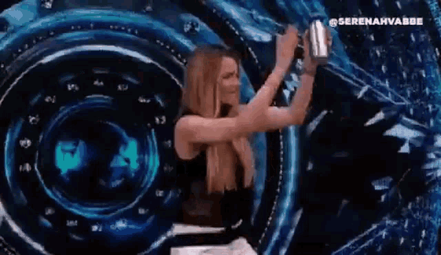 a woman is taking a picture of herself in front of a large screen .