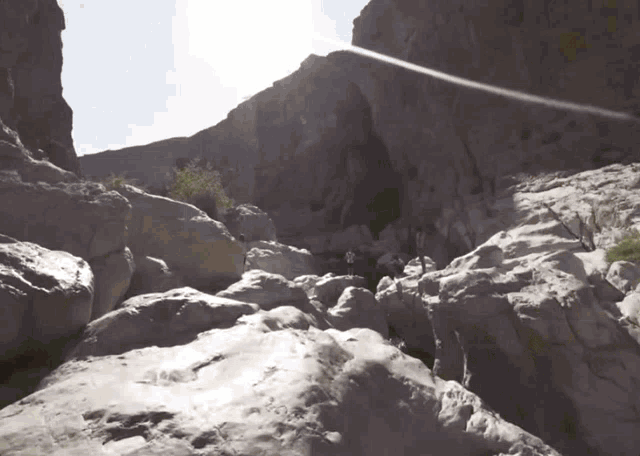 a group of people are walking down a rocky path