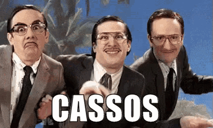 three men in suits and ties are posing for a picture and the word cassos is on the bottom of the picture .