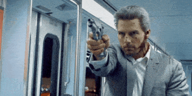 a man in a suit is holding a gun in front of a train