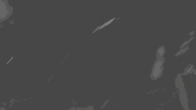 a blurry black and white photo of a person playing an electric guitar .