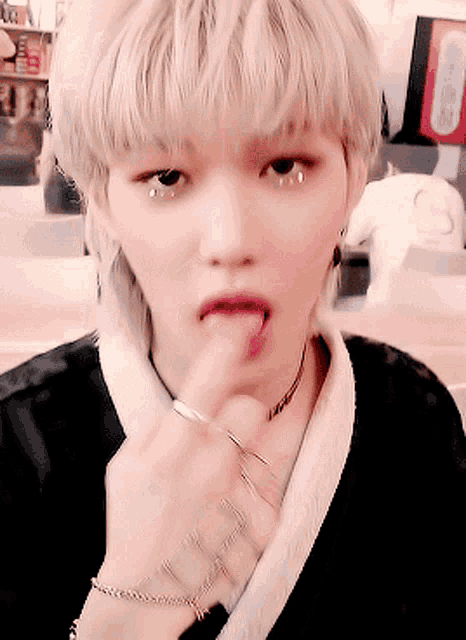 a woman with blonde hair is sticking out her tongue