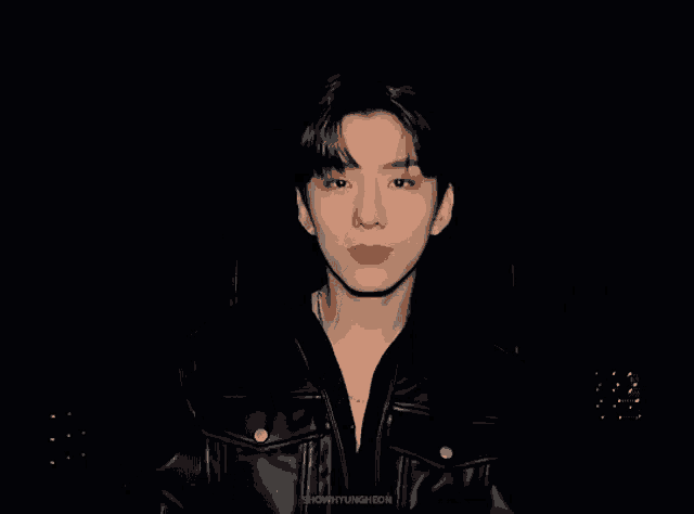 a young man with red lipstick is wearing a black leather jacket and a necklace .