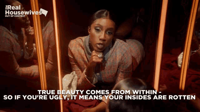 a woman is looking at herself in a mirror with the words true beauty comes from within