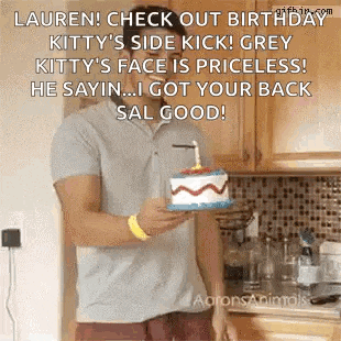 a man is holding a birthday cake with a candle on it in a kitchen .