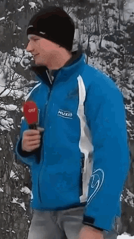 a man wearing a blue jacket with the word muxel on the front