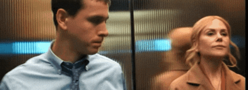 a man and a woman standing next to each other in an elevator