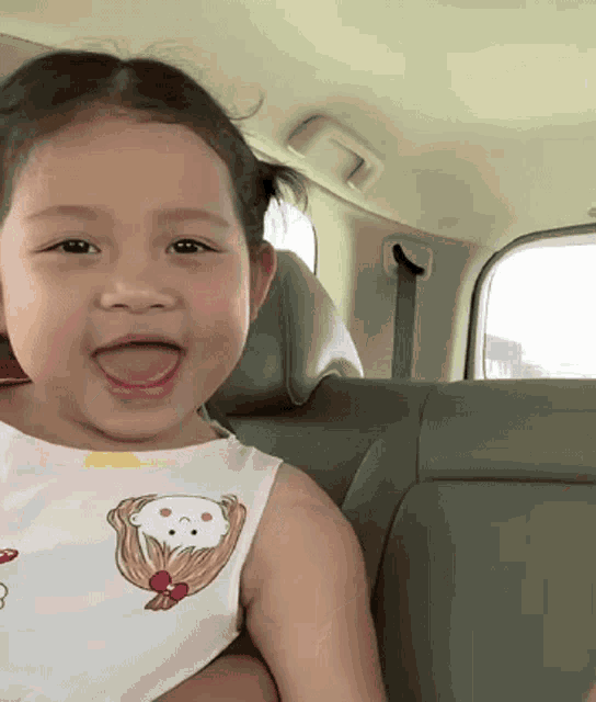 a little girl in a car with her tongue out