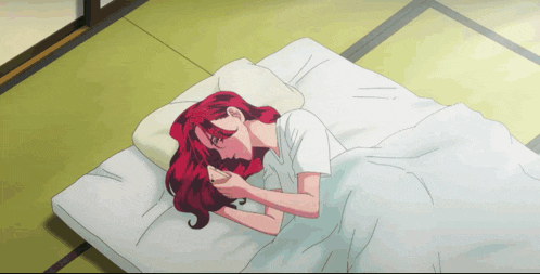 a woman with red hair is laying on a bed with a white blanket