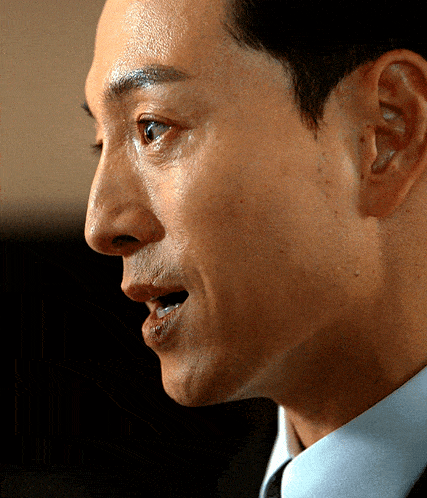 a close up of a man 's face with his mouth open and his eyes closed