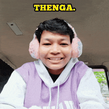 a young man wearing ear warmers and a purple shirt with the word thenga on it