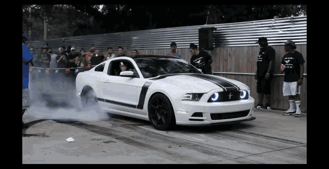 a white ford mustang with a black stripe on the side