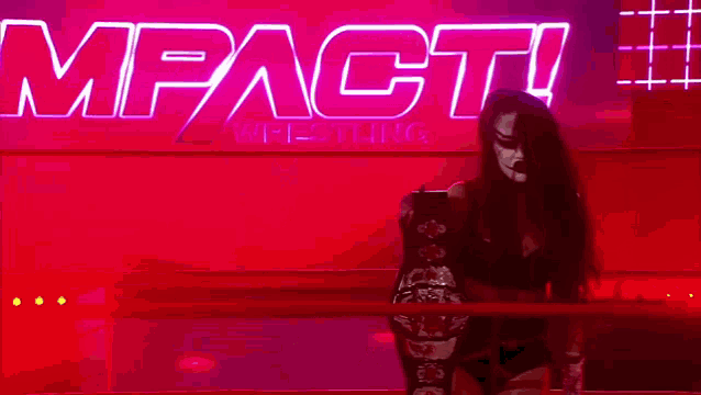 a woman is standing in a wrestling ring holding a championship .