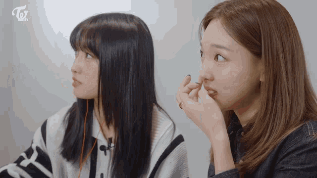 two women are sitting next to each other with the word twice on the bottom right
