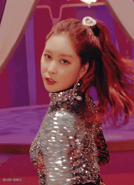a woman with red hair is wearing a sequined top
