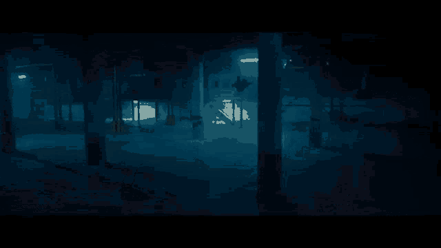 a person is flying through the air in a dark room while holding a sword .