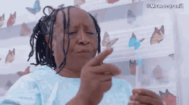 a woman in a hospital gown is pointing her finger at something .