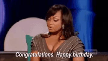 a woman is sitting on a couch with her eyes closed and saying `` congratulations . happy birthday . ''