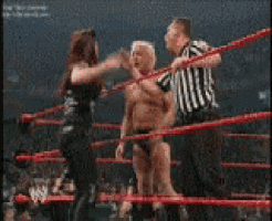 a man and woman are fighting in a wrestling ring while a referee watches