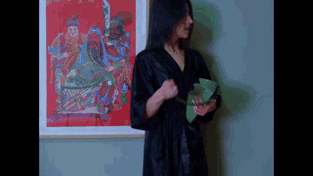 a woman in a black robe is holding a green phone