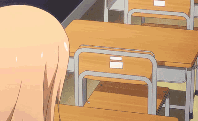 a girl stands in front of a row of wooden desks with a white label on them