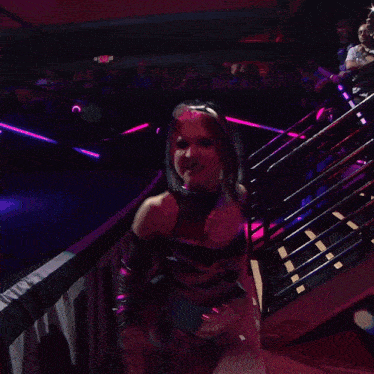a woman in a pink and black outfit stands in front of a crowd with the word nike on her shirt