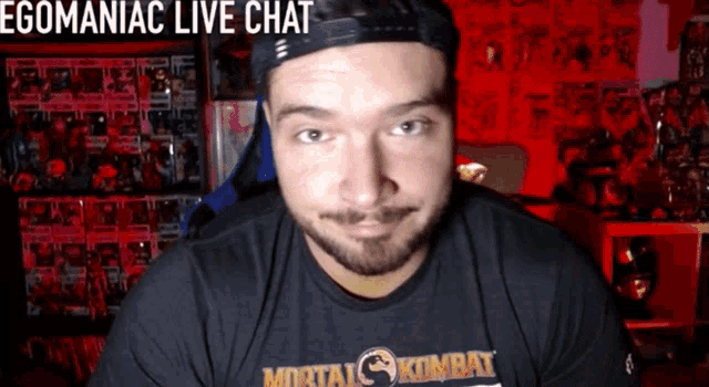 a man wearing a black mortal kombat shirt looks at the camera