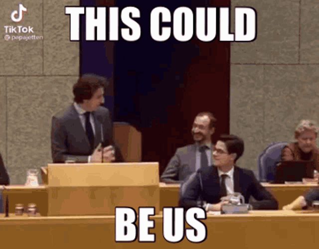 a man in a suit and tie is giving a speech in front of a group of people with the caption this could be us